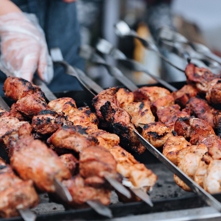 A picture of meat being cooked on a grill.